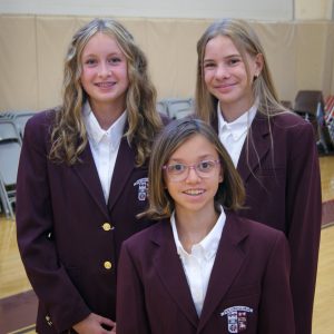 Three female students in uniform at open house